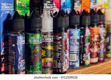Ufa, Russia, 5 July, 2020: E-liquid e-juice High vape for electronic cigarette vaping device , on counter in smoke vapor in vape bar in bottles. brand
