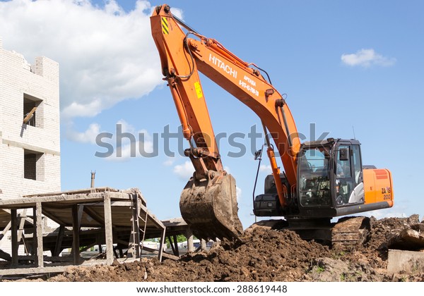 UFA/BASHKORTOSTAN -\
RUSSIA 13th June 2015 - Orange digger excavates soil in preparation\
for new apartments for young families in Ufa city Bashkortostan\
Russia in June\
2015