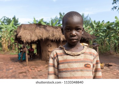 Uganda. 21 June 2017. A Boy Standing In Front Of A Wattle-and-daub House In Rural Uganda.