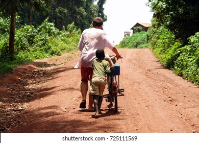 Uganda Boy And Foreigner Man Walking With Bicycle To The Hill In Jinja Town , Uganda