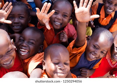Uganda. June 13 2017. A group of happy primary-school children smiling, laughing and waving. They are dressed in school uniforms.