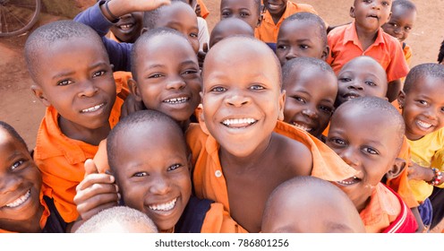 Uganda. June 13 2017. A group of happy primary-school children smiling, laughing and waving. They are dressed in school uniforms.