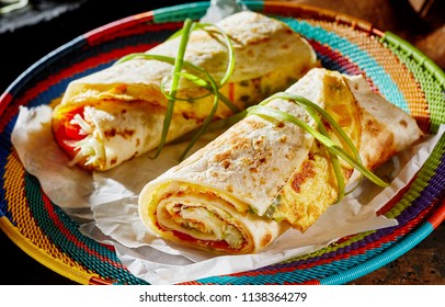 Ugandan Rolex Rolls Street Food On A Brightly Colored Basket With Egg Omelette And Vegetables Rolled In A Fried Chapati