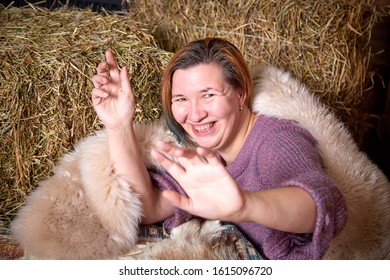 Ugly Adult Aged Woman In A Fur Cape On The Couch With Hay In The Room Or In The Hayloft With Wooden Walls. Rustic Style In The Interior During Photoshoot