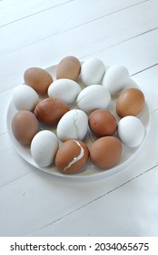 Ugly Boiled Eggs Of Two Colors Lie On A Flat White Plate.