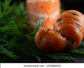 Ugly Fresh Carrots With Green Leaves. In The Background Is A Carrot Cake. Horizontal Orientation