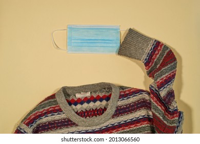 Ugly Sweater With Surgical Mask On Plain Background, Concept Autumn New Normal