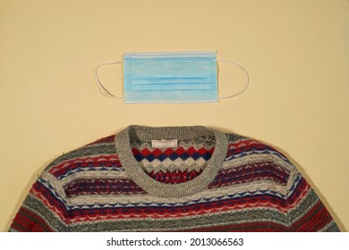 Ugly Sweater With Surgical Mask On Plain Background, Concept Autumn New Normal