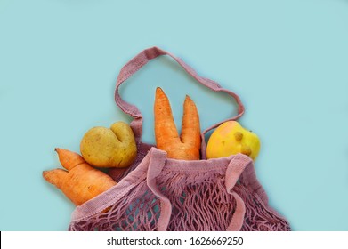 ugly vegetables and fruits in a string bag: potatoes, carrots and an apple. Mesh shopping bag Eco bag. The concept of ecology, not plastic. Healthy food. Copy space., top view. zero waste concept - Powered by Shutterstock