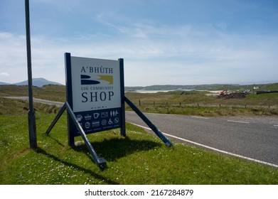 Uig, Scotland, UK: June 6 2022: Sign For Uig Community Shop On Isle Of Lewis With Icons For Fuel, Shopping, Refreshments Etc. Road, Fields, Beach And Sea In Background. Sunny Day, No People.
