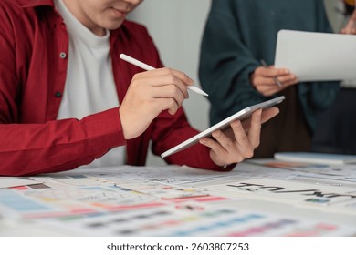 UIUX Development and Digital Tools. Designer focusing on a digital interface while collaborating on a complex project.