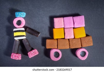 UK August 19 2020: Picture of person and vehicle made from Liquorice allsorts on a black background