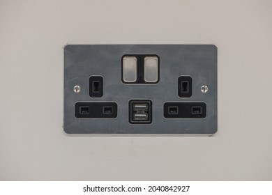 UK brushed chrome double socket with USB port on a wall. Close up view. - Shutterstock ID 2040842927