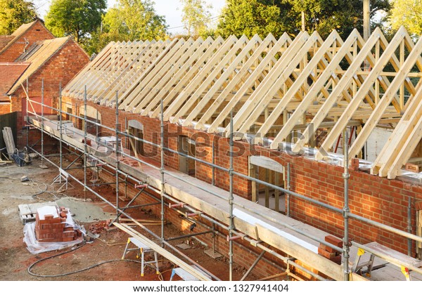 UK building site with\
scaffolding. Part of a period house is restored using modern\
building methods.
