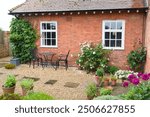 UK cottage garden with hard landscaping, patio furniture bistro table and chairs