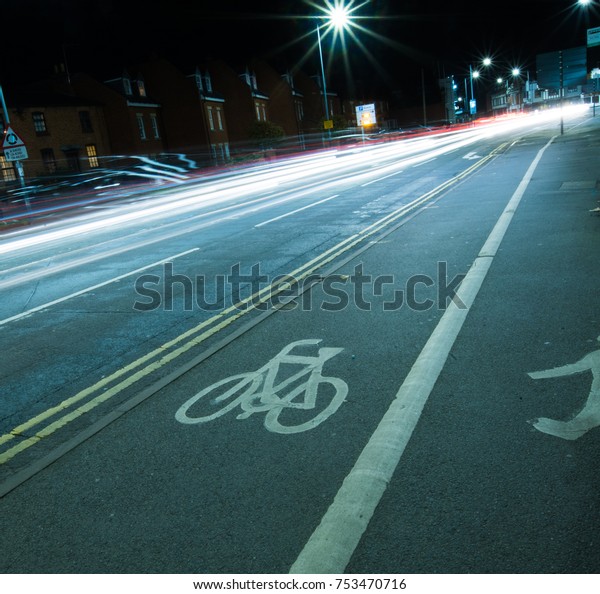 UK cycle lane at night with street lamp and\
vehicle lights slow exposure