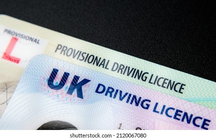 UK Driving Licence. Provisional and Full licence cards isolated on dark background. Macro. Selective focus. 