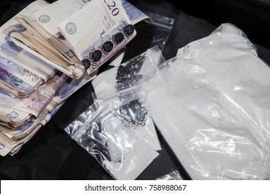 UK Drug Crime. Cash And Cocaine. A Dealers Cash From Selling Illegal Drugs. White Powder In Bags With Substantial Amount Of Money.