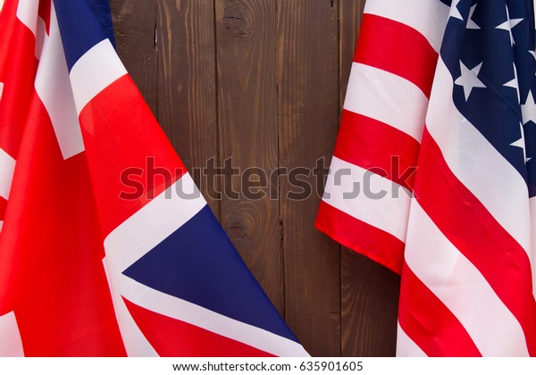 UK flag and
USA Flag on wooden brown
background.