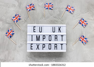 UK Flags And Text EU UK IMPORT EXPORT On Gray Background. Brexit, Trade Deal, Transition Period, Changes And New Rules Concept. Flat Lay, Copy Space