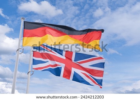 UK and German flags flutter in the wind.