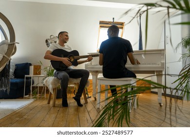 UK, London, Gay couple playing piano and guitar at home - Powered by Shutterstock