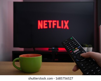 UK, March 2020: TV Television Netflix logo on screen with remote control in home