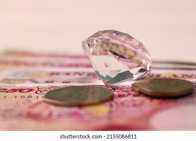 UK Money Bills With Large Diamond Close Up. Big Amount Of United Kingdom Pounds And Huge Transparent Gem On Table. Business And Jewellery Concept For England