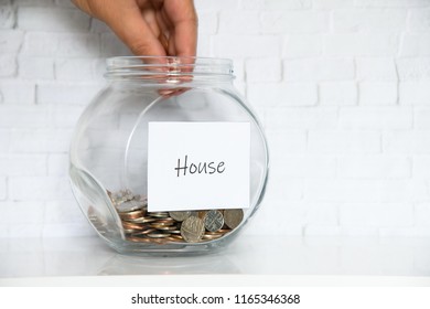 UK Money Jar On A White Shelf In A Household Living Room. Saving For House Concept