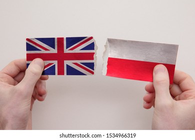 UK And Poland Paper Flags Ripped Apart. Political Relationship Concept