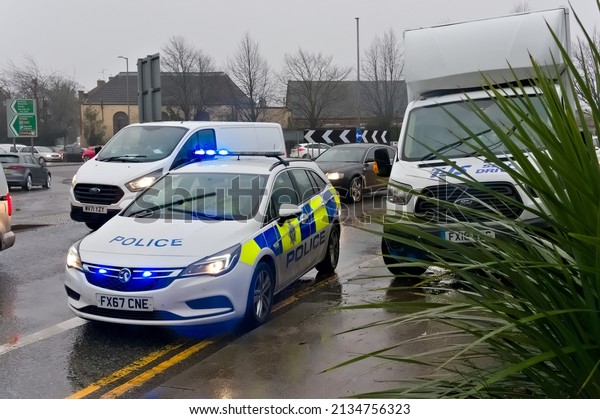 UK Police\
car with flashing lights in the rain besides a stopped van on John\
Adam\'s Way. Boston Lincs UK  Dec\
2021