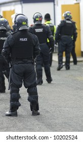 Uk Police Officers In Full Riot Gear At The Scene Of A Public Disturbance.