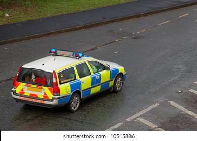 Uk Police Vehicle On A Wet Road With The Blue Lights On