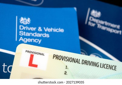 UK Provisional Driving Licence card placed on blurred books used for Driving Theory test. Document for Learner drivers. Genuine document. Stafford, United Kingdom - August 18 2021.