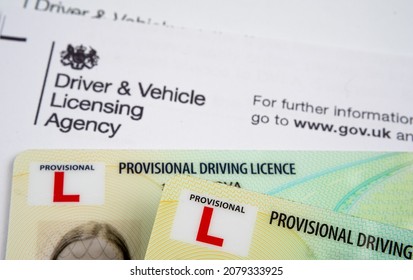 UK Provisional Driving Licence cards placed on top of the genuine letter form Driver and Vehicle Licensing Agency. Stafford, United Kingdom, November 21, 2021.
