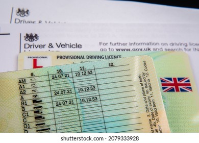 UK Provisional Driving Licence cards placed on top of the genuine letter form Driver and Vehicle Licensing Agency. Stafford, United Kingdom, November 21, 2021.