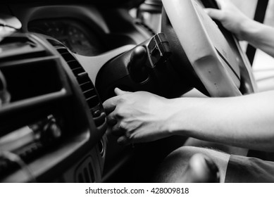 UK Right Hand Drive Car. Black White Photography Driver Closeup Hand Turning On Ignition, Background Dashboard