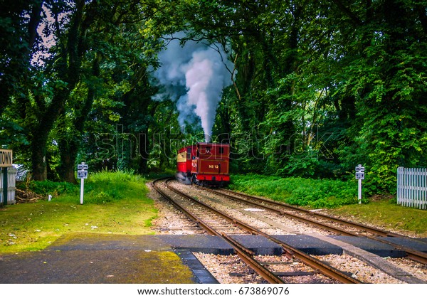 UK Steam Train with train tracks and switch in the\
sunshine light. Train tracks Train ride on railroads. Rail tracks\
route steam railway.Old railway car carriage Steam energy. Steam\
engine trains UK