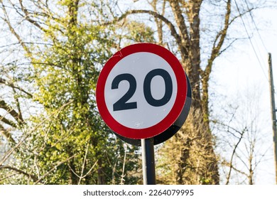 UK Traffic sign showing a 20 mph maximum speed limit with a red and white warning circle