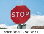 UK Traffic sign showing a stop sign with a red and white warning hexagon	