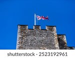 The UK union flag flying from one of the towers at Dover castle