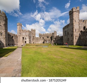 UK - Wales - Caernarfon - The Impressive Panorama Of Carnarvon Castle With Its Massive Stone Walls And Towers Under Summer Sunny Blue Sky