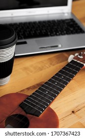 Ukelele On A Table With A Laptop And A Cap Of Coffee