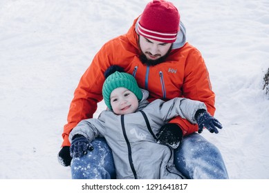 UKRAINE, BILA TSERKVA - JANUARY 7, 2019; Dad and son ride down a hill in winter. Selective focus. Happy moments - Shutterstock ID 1291641817
