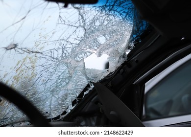 Ukraine, Bucha - 04.21.2022: Broken Car Windshield, Bullet Holes And Old Blood Spatter. View From Inside The Car. Cemetery Of Technology