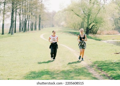 Ukraine, City Of Romny, April 27, 2015: Two Smiling Sports Women Are Running In Nature. Running, Fitness