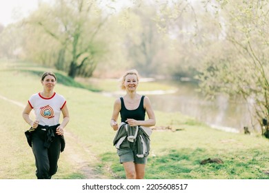 Ukraine, City Of Romny, April 27, 2015: Two Smiling Sports Women Are Running In Nature. Running, Fitness