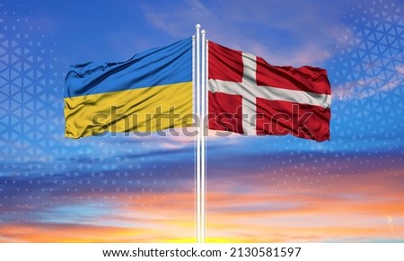 Ukraine and Denmark two flags on flagpoles and blue sky

