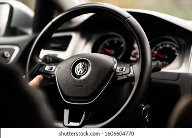 Ukraine- February 10, 2018: Man holding black steering wheel with logotype of seven generation Volkswagen golf by German automaker Volkswagen while driving