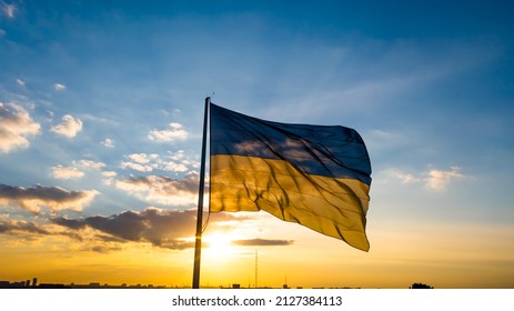 Ukraine Flag against the backdrop of sunrise. Large yellow blue Ukrainian state flag. Independent Ukraine.
 - Shutterstock ID 2127384113
